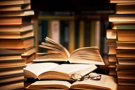 a stack of books with glasses on top of them